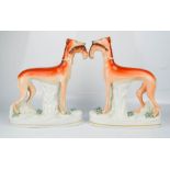 A pair of Staffordshire greyhounds with rabbits.