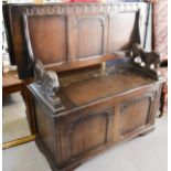 A monks bench, with carved lion form arms.