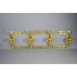 A cast brass wall hanging coat rack.