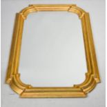 A gilt wood wall mirror, cushion moulded form, 88 by 60cm.