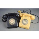 Two bakelite telephones, one cream and the other black.