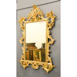 A large Italian 18th century giltwood wall mirror, carved scrollwork border, 114 by 77cm.