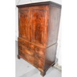 A 19th century mahogany linen cupboard, with moulded upper frieze, two cupboard doors enclosing