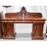 A 19th century Victorian sideboard, with shaped and carved back depicting a laurel wreath, cushion