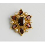 A 9ct gold Victorian style garnet and split seed pearl brooch, set with seven faceted garnets, 5.