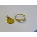 An Indian gold ring and a yellow metal pendant, 4g total.