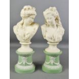 A pair of 19th century Parian ware female busts, raised on green plinths decorated with bows and
