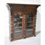 A Victorian carved oak bookcase. 142cms tall x 46cms deep x 138cms wide