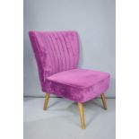 A modern purple velvet upholstered cocktail chair.