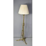 A Victorian brass standard oil lamp, converted for electricity, with cream silk shade.