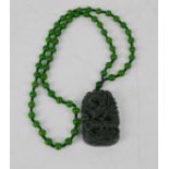 A Chinese Heitian jade carved dragon and flaming star pendant and jade bead necklace.