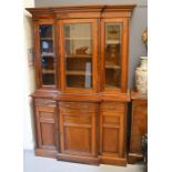 A late 19th century rosewood break front book case, with three glazed doors above drawers and