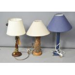 Three table lamps, two with cream shades.
