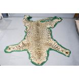 A leopard skin rug, 210 by 150cm.