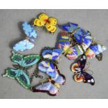 A group of enamelled brooches and necklace, in the form of butterflies.