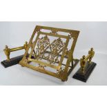 A brass music/reading stand with two cast and brass firedogs.