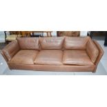 A vintage three seater brown leather settee, with chrome feet.