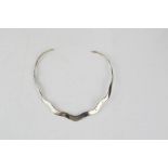 A silver necklace, a silver 'feather' form necklace, silver earrings.