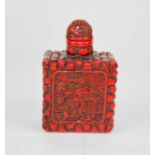 A vintage coral style carved snuff bottle depicting a dragon.