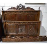 A French carved bed frame, with upper frieze and finials to the back board, and a carved end board.