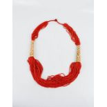 A Vintage 1930s Chinese red coral bead multistrand necklace with carved bone sleeves.