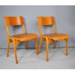 A pair of wooden school chairs.