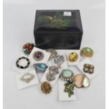A group of sixteen brooches in a box.