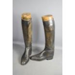 A pair of Tom Hill of London antique boot trees and leather riding boots.