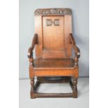 A 17th century oak wainscot armchair, with scroll carved top, the back bearing initials W.P.