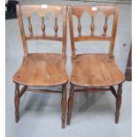 A pair of oak chairs with spindle backs.