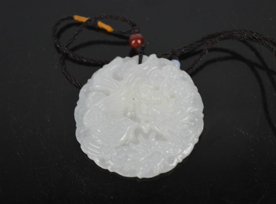 A Chinese natural white jade hand carved dragon and phoenix pendant necklace..