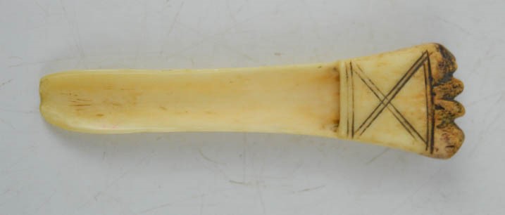 An antique carved bone apple corer.