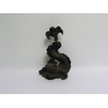 Black painted cast iron doorstop in the form of a classical scrolling dolphin, 34cm high.