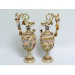 Pair of Capodimonte ewers profusely decorated with moulded classical scenes of revelry, with cherubs