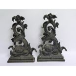 Pair of black painted cast iron doorstops in the form of classical scrolling dolphins, each 41cm