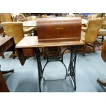 Vintage Singer treadle sewing machine on stand with wrought iron supports.