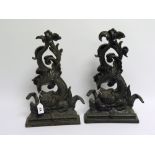 Pair of black painted cast iron doorstops in the form of classical scrolling dolphins, each 41cm