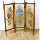 Edwardian beech folding low draught screen, each of the three glazed panels painted with flowers &