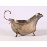 George V silver sauce boat with scroll handle, raised on three shell cabriole supports with