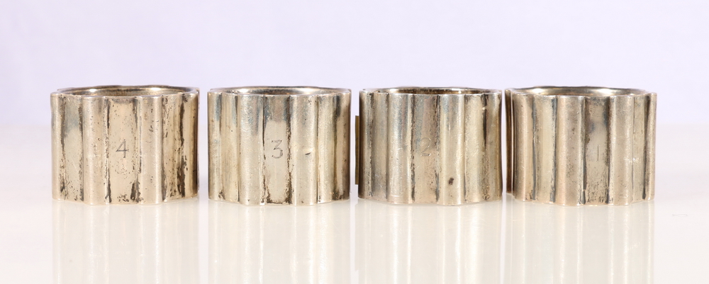 Set of four George VI silver napkin rings of cog form, individually numbered 1-4 by Bishton's Ltd,