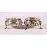 Pair of Victorian silver salt cellars with repoussé scroll and floral decoration, gadrooned rims