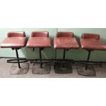 Set of four leather bar stools raised on metal bases, 85cm tall
