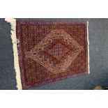 Persian mat with all over diamond design, red ground and boarder, 100 x 75 cm.