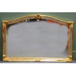 Gilt and glazed frame, the arch top with foliate surmount, 128 cm wide 88 cm tall.