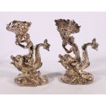 Pair of cast white metal figures models as a king (possibly Neptune) and Queen riding dolphins