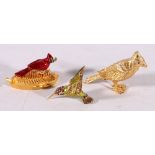 Two Estee Lauder perfume compacts in the form of birds and also a model of a humming bird, the