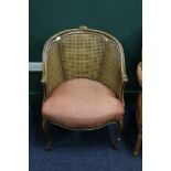 French style bergere tub chair with carved top rail, raised on cabriole supports, 87cm tall.