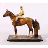 Cold painted metal table lighter in the form of a jockey on horseback, 20cm wide