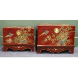Two lacquered oriental inspired storage boxes on stands, the bodies decorated with foliage and