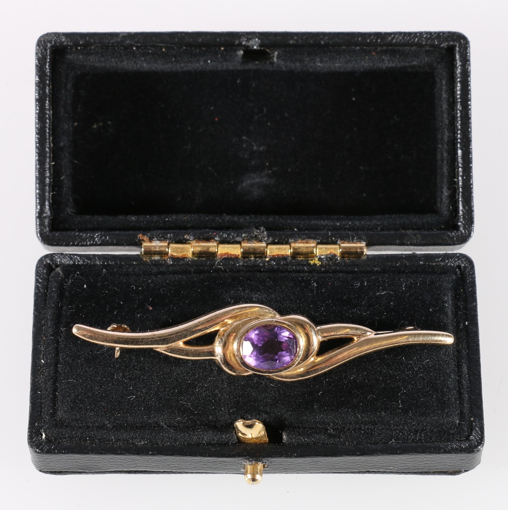9ct yellow gold crossover bar brooch set with central faceted amethyst, 3.2g